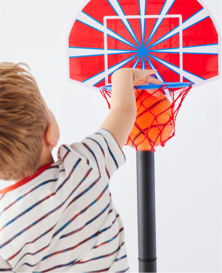 Enfant qui joue avec un panier de basketball IDKIDS