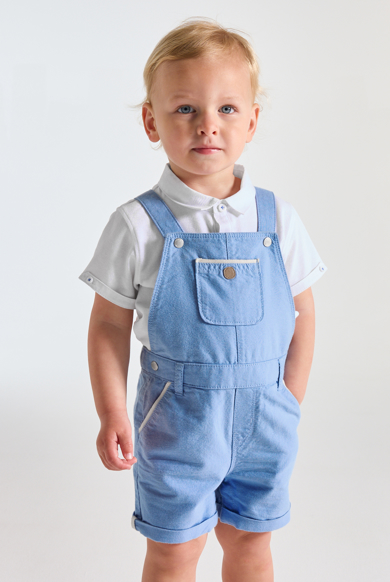Peto corto azul y polo de punto piqué blanco bebé niño